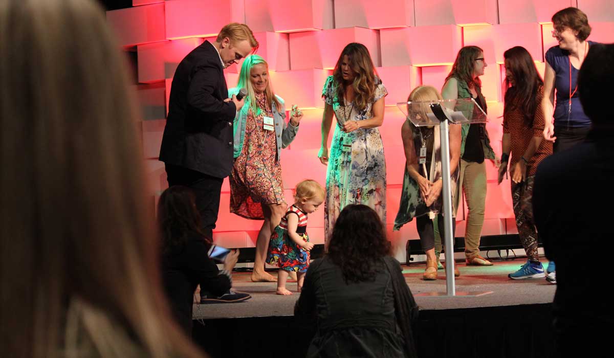 Jeff Goins and conference attendees dancing on the stage during a break