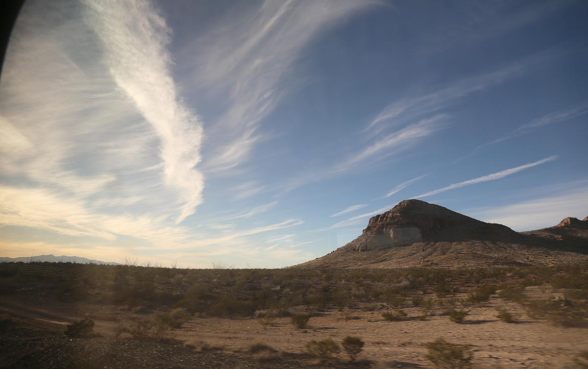 Sky with clouds, brush flats, hills and mountains