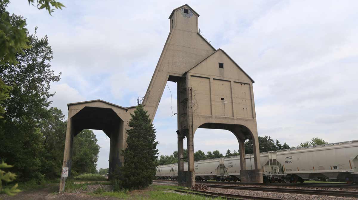 The concrete structure of the old coaling tower straddling the mainline tracks in DeKalb, IL