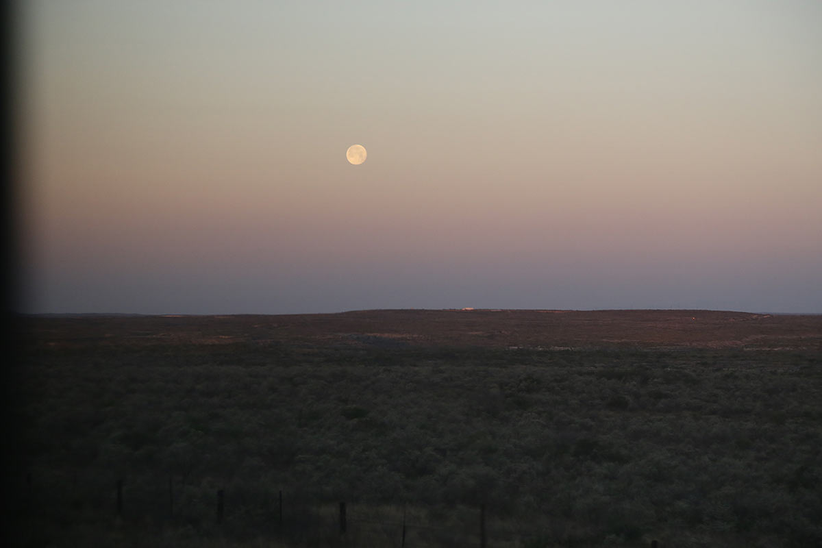 Full moon, almost sunrise and brush land