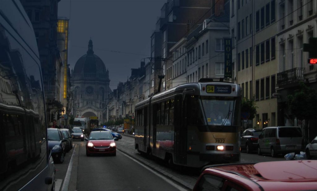 Brussels street at dusk with cars and tram