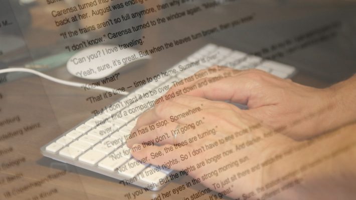 Text on computer screen superimposed over image of hands on keyboard