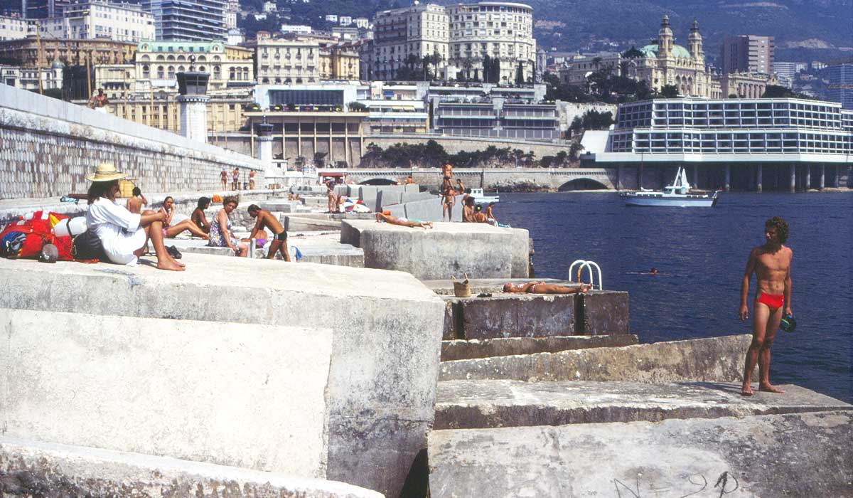 Monaco: people hanging out on the breakwater in the harbor