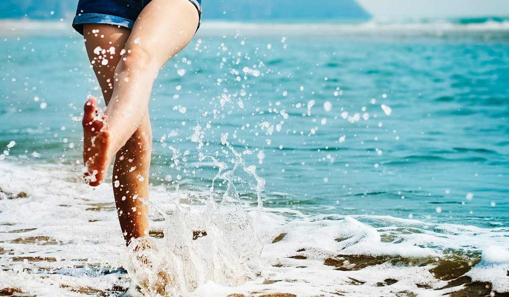 Seashore, feet splashing in the water