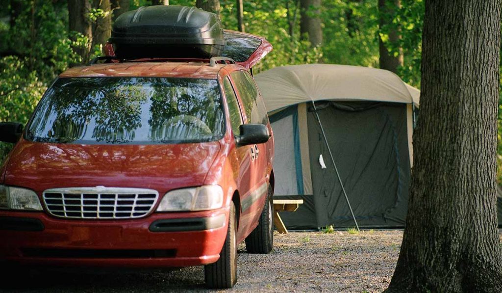 Our van by a tent at a campsite