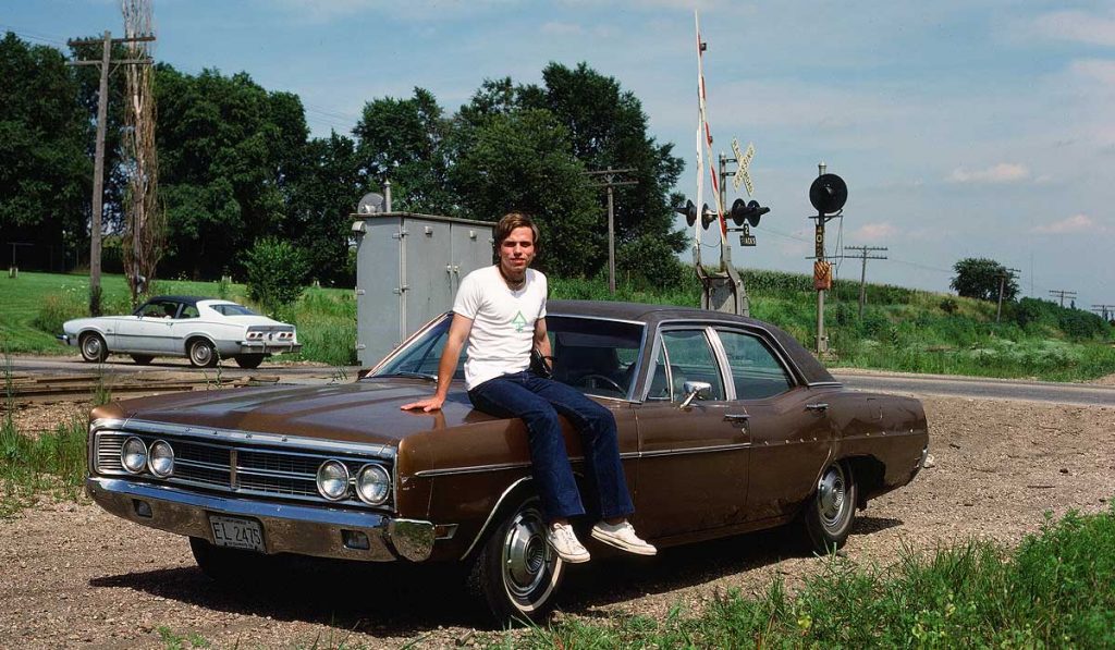 Claes sitting on the hood of a big old car. Photo from 1978.