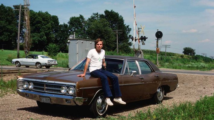 Claes sitting on the hood of a big old car. Photo from 1978.