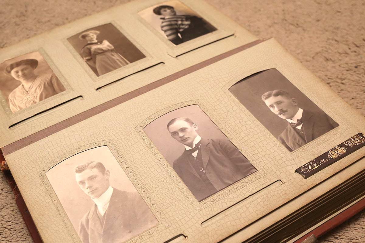 Old photo album with pictures of men and women