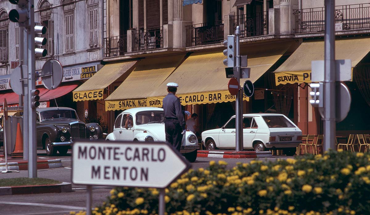 Downtown Monaco: a policeman directing traffic, including a VW Beetle and a Rolls Royce