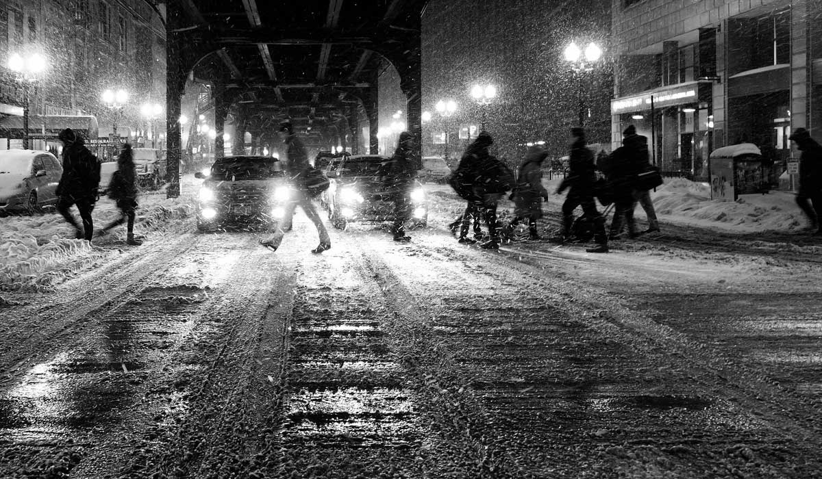 Winter city street, people crossing in snow and slush