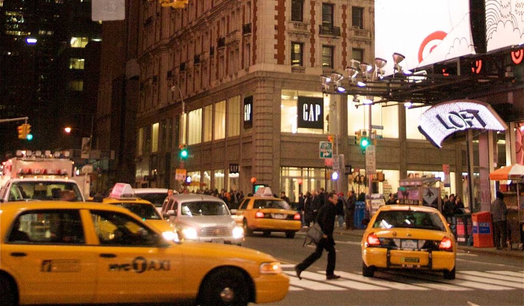 New York street at night with several taxis and other cars