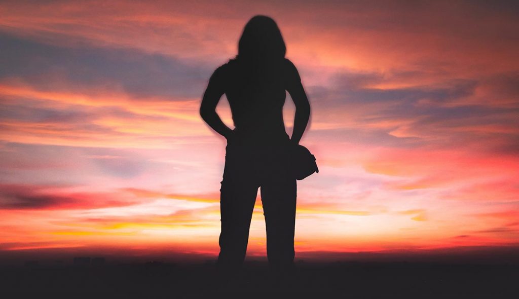 Silhouette of woman against red sky