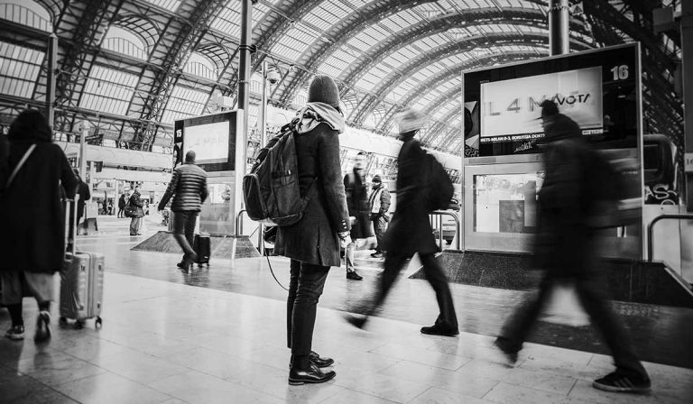 Woman standing, waiting in train terminal