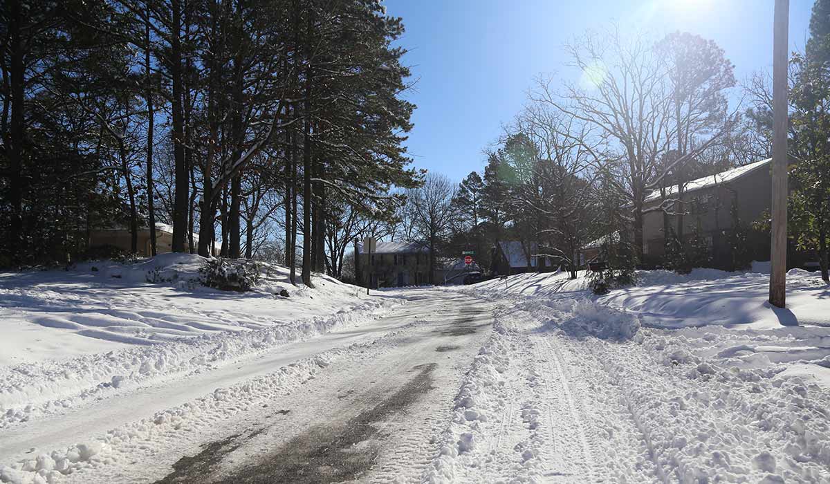 sunshine, snow on ground, houses and trees